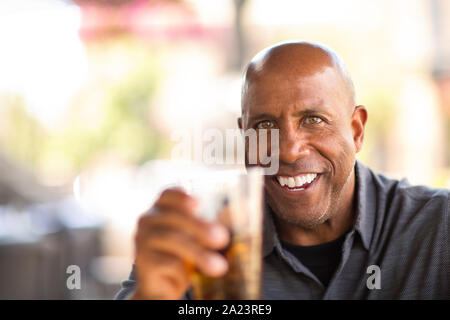 Young African American man de boire dans un restaurant. Banque D'Images