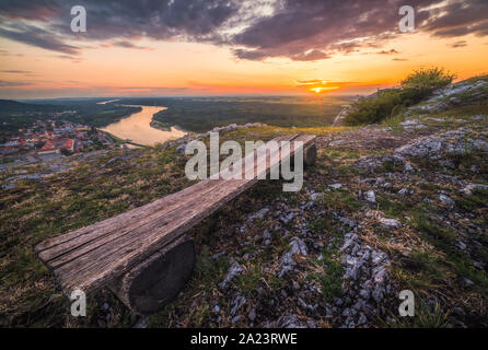 Paysage. Magnifique Coucher de soleil sur les rochers et la rivière. Banc en bois en premier plan. Banque D'Images