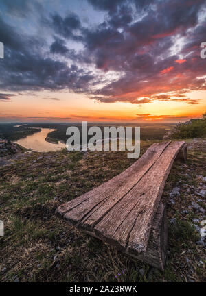 Magnifique Coucher de soleil sur Paysage avec Danube. Banc en bois en premier plan. Banque D'Images