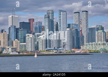 Vols navettes est éclipsé par les tours du quartier financier du centre-ville de Toronto en approche finale à l'aéroport Billy Bishop. Banque D'Images