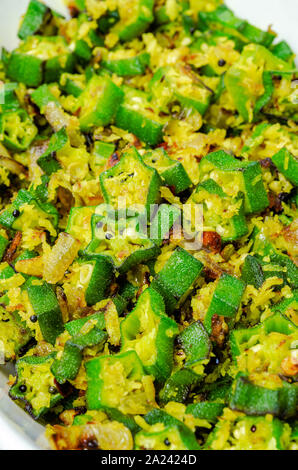 Libre d'okras sautés avec de la noix de coco râpée et la moutarde dans un plat Banque D'Images