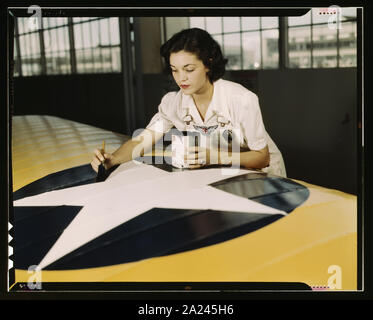 Peinture de l'insigne américain sur les ailes d'avions est un travail que Mme Irma Lee McElroy, un ancien employé de bureau le fait avec précision et de zèle patriotique. Mme McElroy est un employé du service civil à la Naval Air Base, Corpus Christi, Texas. Son mari est un instructeur de vol Banque D'Images