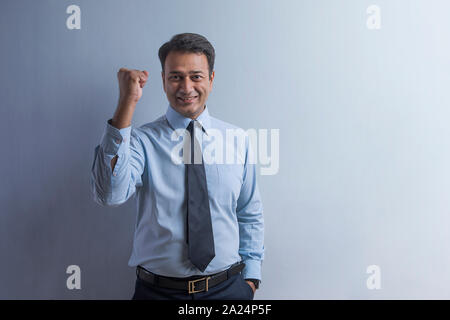 Smiling businessman in vêtements officiels montrant peu différent avec une main représentent la force et la confiance Banque D'Images