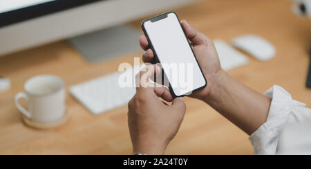 Close-up view of businessman holding smartphone écran vide dans son bureau moderne Banque D'Images