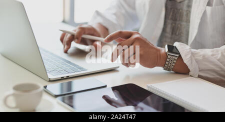 Vue rapprochée de la dactylographie professional businessman typing on laptop computer tout en travaillant sur ses projets actuels Banque D'Images