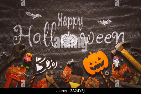 Happy Halloween journée avec construction bricolage outils pratiques sur craie noire fond conseil concept. Télévision jeter dessus. Banque D'Images