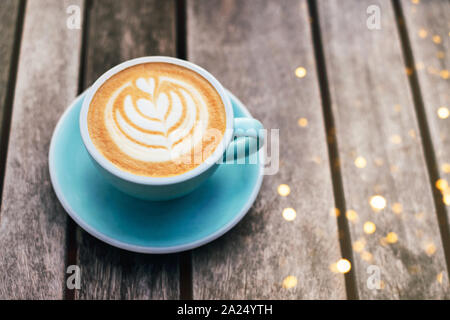 Cappuccino avec mousse écumeuse, tasse à café bleu Vue de dessus gros plan sur fond de bois gris. Mise à plat de style. Banque D'Images