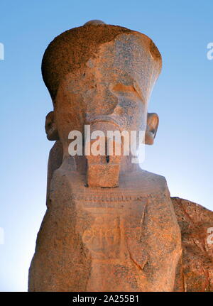 Statue d'un pharaon au complexe du temple de Karnak, à Louxor, Égypte. La construction du complexe a commencé pendant le règne de Sésostris I dans l'Empire du Milieu et a continué dans la période ptolémaïque, bien que la plupart des bâtiments datent du Nouvel Empire. La zone autour de Karnak était le principal lieu de culte de la xviiie dynastie triade thébaine avec le dieu Amon à sa tête. Il fait partie de la ville monumentale de Thèbes. Banque D'Images