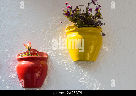 Pots colorés avec des plantes accroché contre un mur blanc dans Cesme, Izmir, Turquie Banque D'Images