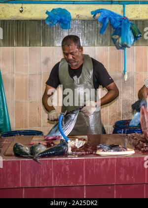 Male, Maldives - Le 16 novembre 2017 : l'homme prépare des poissons thon à la vente à le Marché aux poissons de la ville et de l'île de Male, la capitale des Maldives. Banque D'Images