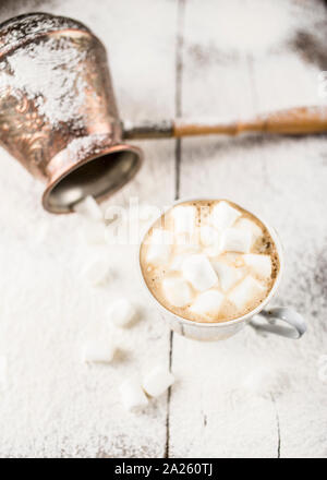 Café noir chaud dans une tasse avec des guimauves cuzve tout près il y a sur la vieille table en bois un saupoudrer de sucre en poudre Banque D'Images