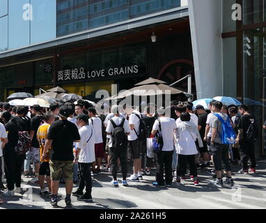 Les jeunes Chinois à la mode foule se rassemble à l'extérieur d'un magasin pour prendre part à un tirage au sort pour designer chaussures formateur unique. Beijing, Chine Banque D'Images