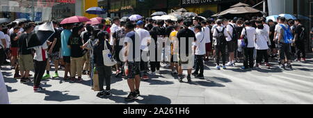 Les jeunes Chinois à la mode foule se rassemble à l'extérieur d'un magasin pour prendre part à un tirage au sort pour designer chaussures formateur unique. Beijing, Chine Banque D'Images