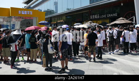 Les jeunes Chinois à la mode foule se rassemble à l'extérieur d'un magasin pour prendre part à un tirage au sort pour designer chaussures formateur unique. Beijing, Chine Banque D'Images