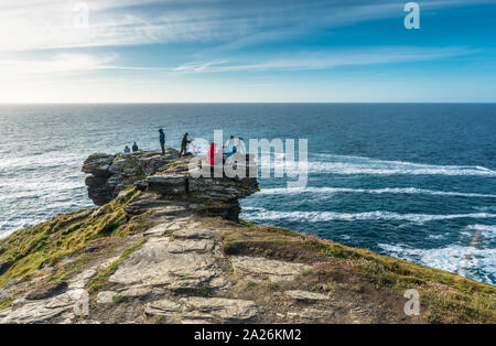 Photographes de Tintagel en attendant le coucher du soleil sur la côte de Cornouailles. Cornwall, Angleterre, Royaume-Uni. Banque D'Images