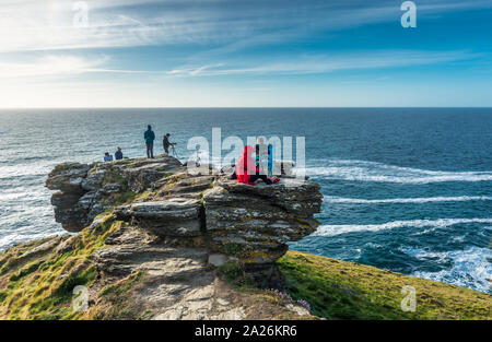 Photographes de Tintagel en attendant le coucher du soleil sur la côte de Cornouailles. Cornwall, Angleterre, Royaume-Uni. Banque D'Images