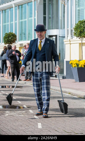 Grand Hotel Brighton portier portant des uniformes intelligents et chapeau melon balayant les ordures jusqu'à l'extérieur de l'hôtel. Banque D'Images