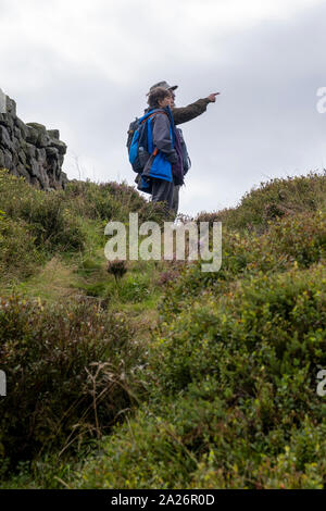 Deux promeneurs contempler la vue sur un sentier près de la Pennine Way, près de Stanbury du West Yorkshire. Banque D'Images