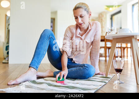 Femme au foyer supprime les remèdes à la maison avec le vin rouge les taches de la moquette de salon Banque D'Images