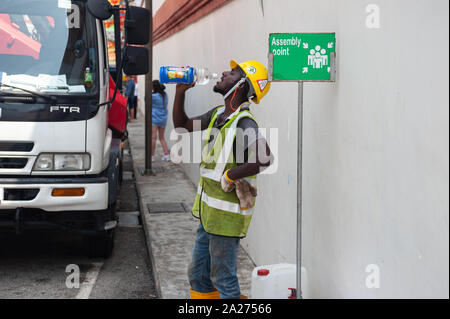 04.04.2018, Singapour, Singapour , - un travailleur dans Chinatown se trouve au bord de la route l'eau potable à partir d'une bouteille. 0SL180404D025CAROEX.JPG [communiqué de modèle Banque D'Images