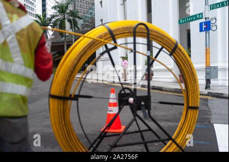 15.04.2018, Singapour, Singapour , - un travailleur est la pose de câbles sur une rue dans le quartier des affaires. 0SL180415D007CAROEX.JPG [communiqué de modèle : Non, PROPE Banque D'Images