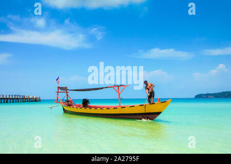 L'homme sur la pêche longtail ou en ferry à Baie sarrasine sur cette île de vacances Sarrasine ; Bay Resort, l'île de Koh Rong Sanloem, Sihanoukville, Cambodge Banque D'Images