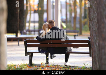 Couple amoureux sur un banc de parc Banque D'Images