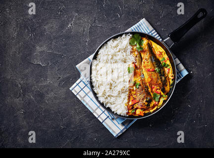 Cari jaune, curry Panang avec Saba maquereau grillé poisson servi avec riz long grain cuit à la vapeur dans une poêle sur une table, vue de dessus, télévision Banque D'Images