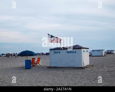 Les petites baraques de bois spraypainted avec stenciiled lettres bleues lire 'vacances' un ligne de plage plage américaine sur une longue journée d'été au bord de la mer. Banque D'Images