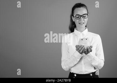 Portrait of young beautiful businesswoman holding piggy bank Banque D'Images