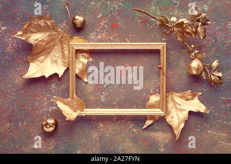 Mise à plat de l'automne avec les feuilles de platane d'or peint et copy-espace dans cadre doré sur toile texturée sombre. Vue supérieure avec l'espace texte. Banque D'Images