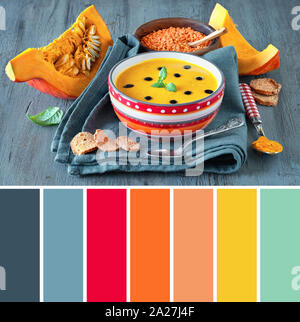 Palette des couleurs épicées de potiron aux lentilles rouges et le curcuma servi avec des feuilles de menthe et de gouttes de vinaigre balsamique sur bois rustique Banque D'Images