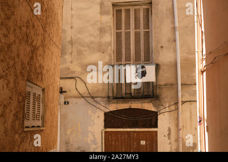 Un drapeau Corse et des armoiries d'une tête de maure avec bandana dans les petites rues de la vieille ville à Ajaccio Corse-du-Sud Corse Banque D'Images