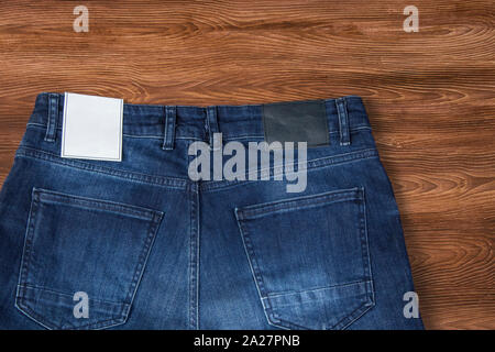 Label Jeans denim, maquette, texture de fond en bois isolé Banque D'Images