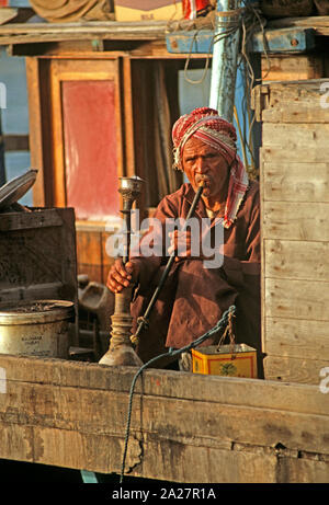 Pipe à eau fumer marin sur un boutre arabe, la Crique de Dubaï, Émirats Arabes Unis Banque D'Images