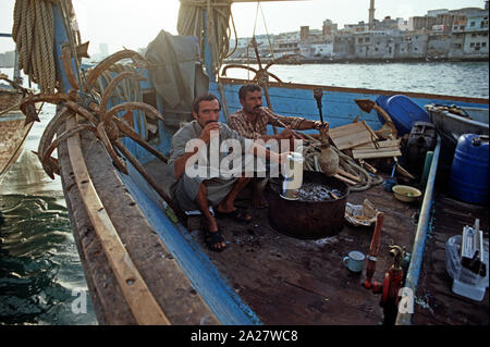 Pipe à eau fumer marins motorisés sur un boutre arabe, la Crique de Dubaï, Émirats Arabes Unis Banque D'Images