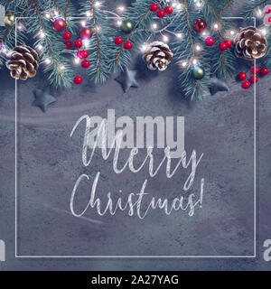 Mise à plat avec des décorations de noël en vert et rouge avec baies givrées, bibelots et phares sur Garland, composition carrée, texte 'Merry Christmas' dans wh Banque D'Images