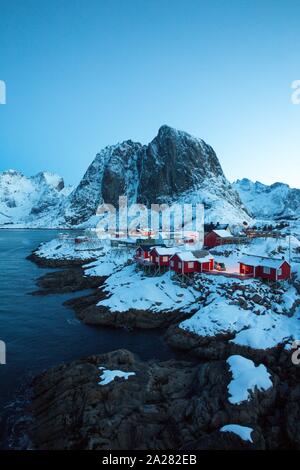 Maison en bois traditionnelle norvégienne rorbu de se tenir sur la rive du fjord et des montagnes au loin. Iles Lofoten. La Norvège. world travel Banque D'Images