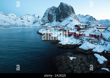 Maison en bois traditionnelle norvégienne rorbu de se tenir sur la rive du fjord et des montagnes au loin. Iles Lofoten. La Norvège. world travel Banque D'Images