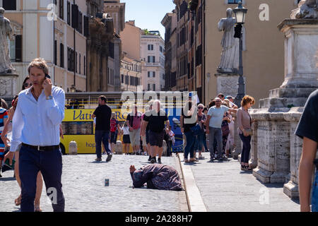 Personnes âgées femme mendiant à genoux au milieu de la foule des touristes sur le pont en direction de la Cité du Vatican. Marché autour et ignorés. Banque D'Images