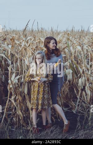 Famille et vie à l'extérieur de la ville. maman et sa fille dans un champ de maïs. Banque D'Images