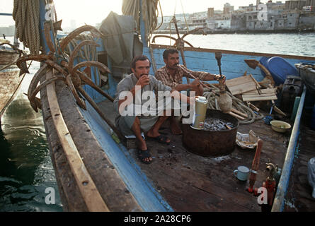 Pipe à eau fumer marins motorisés sur un boutre arabe, la Crique de Dubaï, Émirats Arabes Unis Banque D'Images