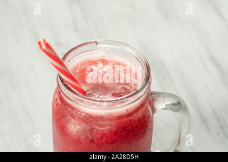 Produits frais bio smoothie rouge dans verre mug sur le tableau blanc, Close up. Boisson aux fruits d'été rafraîchissante. Le concept d'une saine alimentation. Cranberry et raspberr Banque D'Images