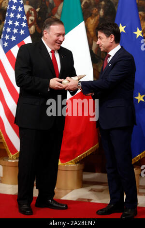 Roma, Italia. 06Th Oct, 2019. Au cours de la photo famille Secrétaire d'État des États-Unis, Mike Pompeo est donné un paquet de parmesan par un journaliste de l'émission de télévision "Le Iene" pour protester contre les tarifs douaniers sur les marchandises européennes, tandis que le Premier ministre italien se trouve à côté de lui, et après un moment prend le parti pris de Pompeo's mains Rome le 1er octobre 2019. Palazzo Chigi. Le secrétaire d'État américain visite le Premier ministre italien. Foto Samantha Zucchi Insidefoto insidefoto Crédit : srl/Alamy Live News Banque D'Images