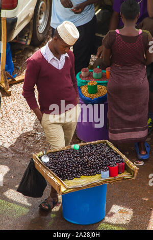 KAMPALA, OUGANDA - 03 octobre, 2012. Un jeune homme se distingue par son plateau de haricots à la vente à la taxis dans Kampala, Ouganda en octobre 03,2012. Banque D'Images