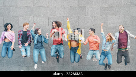 Happy friends jumping ensemble en plein air - jeunes millénaire s'amusant célébrer ensemble en dehors de Banque D'Images