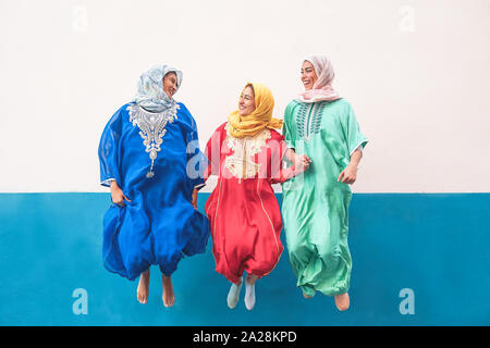 Heureux les femmes musulmanes sautant ensemble en plein air - Arabian teen girls having fun in the city - concept de costume,les gens, la culture et la religion Banque D'Images