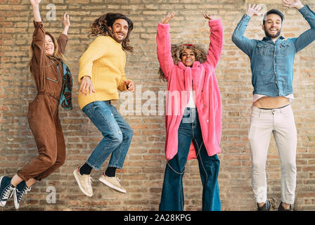 Happy friends jumping ensemble en plein air - jeunes millénaire s'amuser danser et célébrer à l'extérieur Banque D'Images