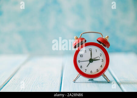 Autumn time change concept - red alarm clock on wood background Banque D'Images
