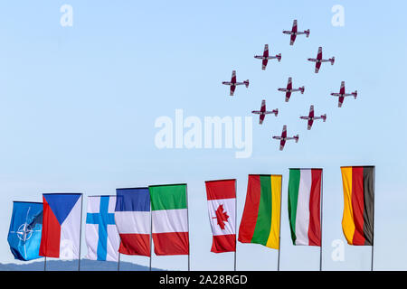 OSTRAVA, RÉPUBLIQUE TCHÈQUE - le 22 septembre 2019 : Journées de l'OTAN. De l'Air suisse PC-7 TEAM effectue un vol de l'affichage. Drapeaux colorés des pays de l'OTAN. Banque D'Images